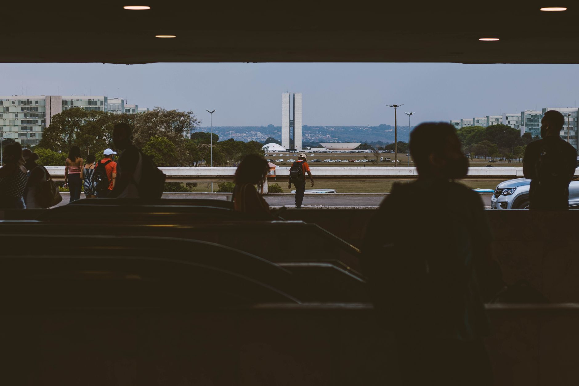 Bandeira do Brasil e prédios governamentais em Brasília representando o cenário econômico e político.