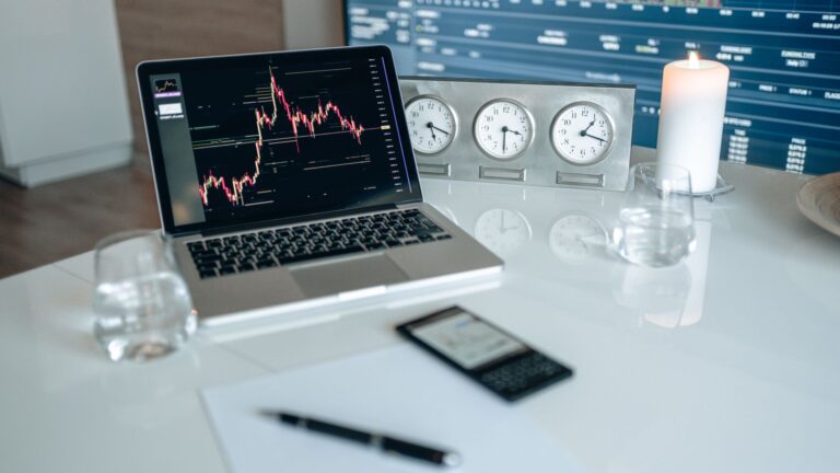 Profissionais do mercado financeiro analisando gráficos de investimentos e tecnologia em telas corporativas