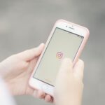 Celular exibindo aplicativos de redes sociais em ambiente corporativo