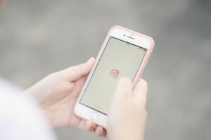 Celular exibindo aplicativos de redes sociais em ambiente corporativo